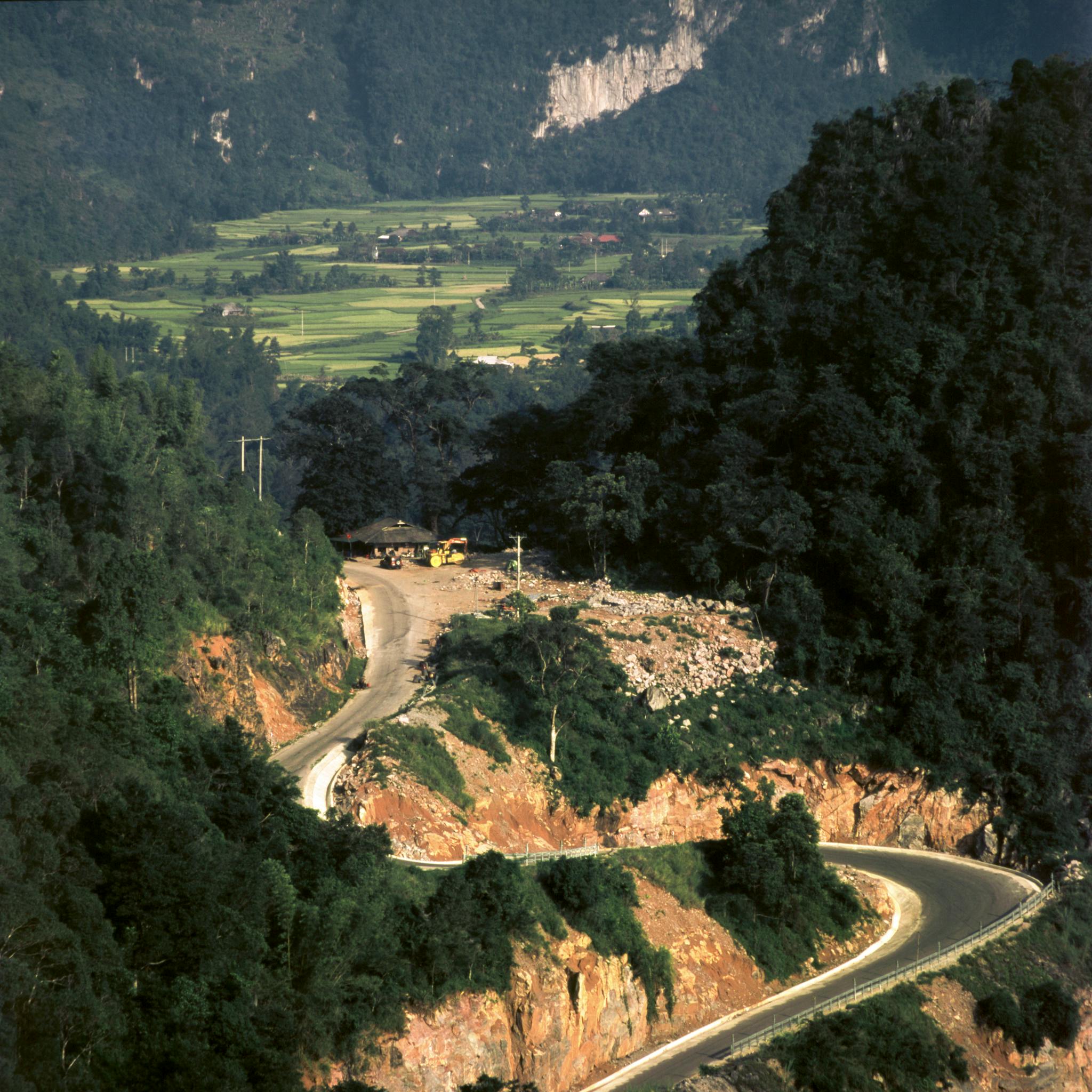 A winding road through lush mountains in Cao Bang, Vietnam, offering stunning natural scenery.