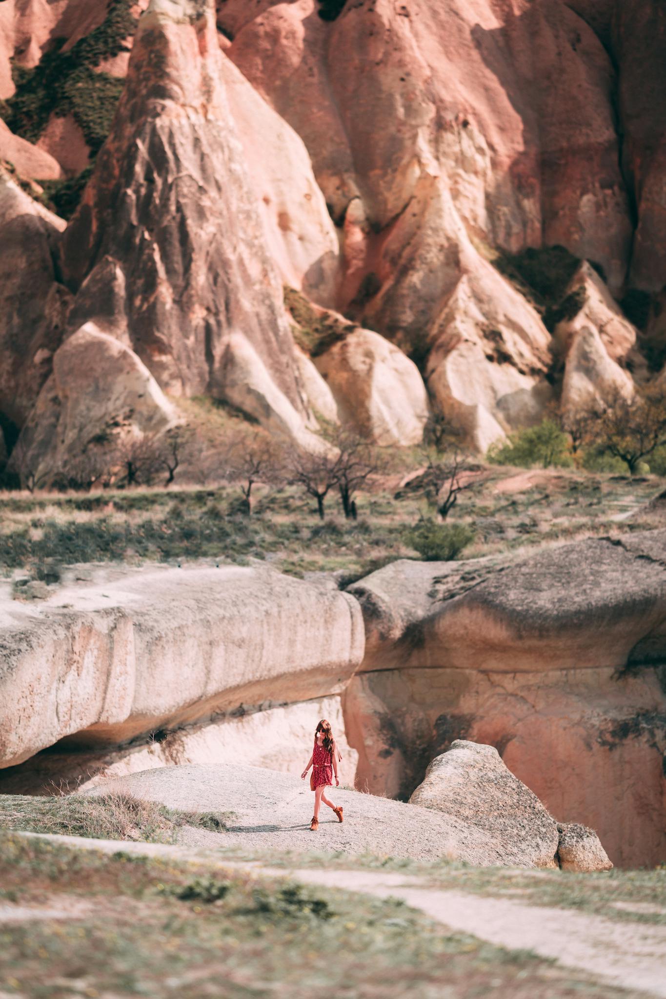 A woman wanders through the stunning natural rock formations of Cappadocia, Turkey.